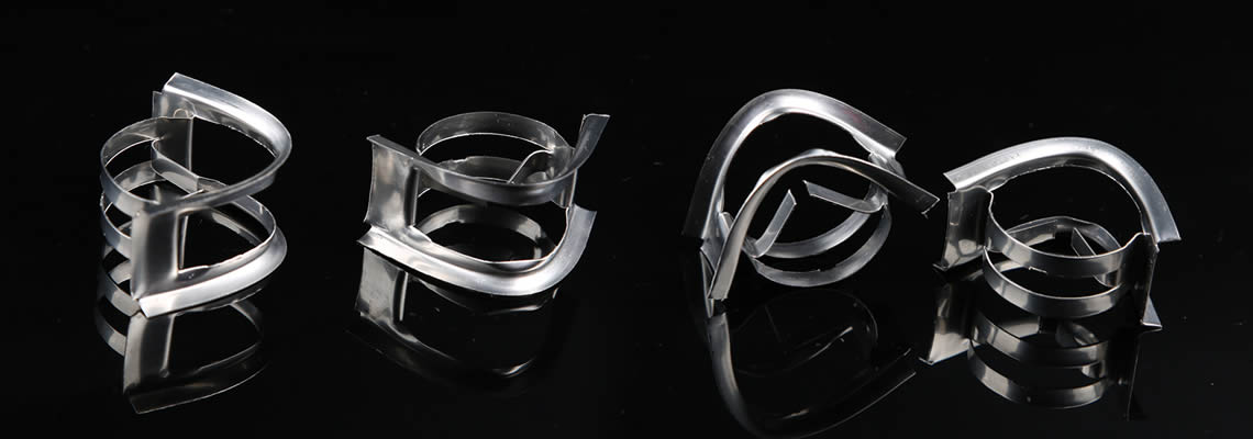Several stainless steel nutter rings lying on the black glass in different posture.