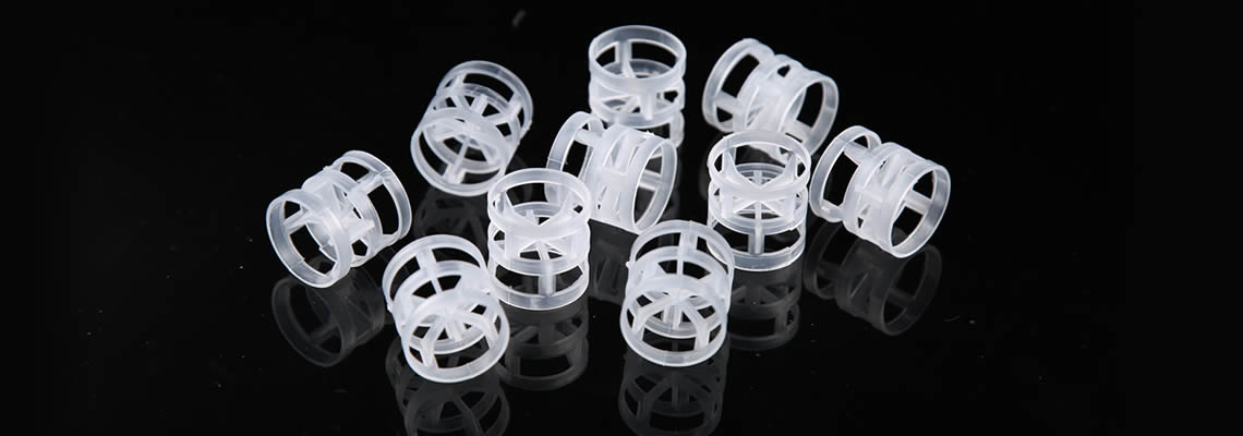 Several PP plastic pall rings are placed on the black glass in different conditions.